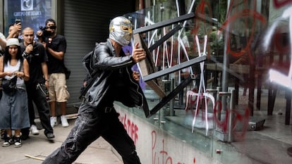Un manifestante vandaliza una sucursal de 'Starbucks' durante la protesta contra la gentrificación, en Ciudad de México.