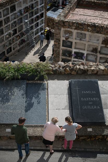 Una familia junto a la lápida de un familiar en el cementerio de Montjuïc de Barcelona.