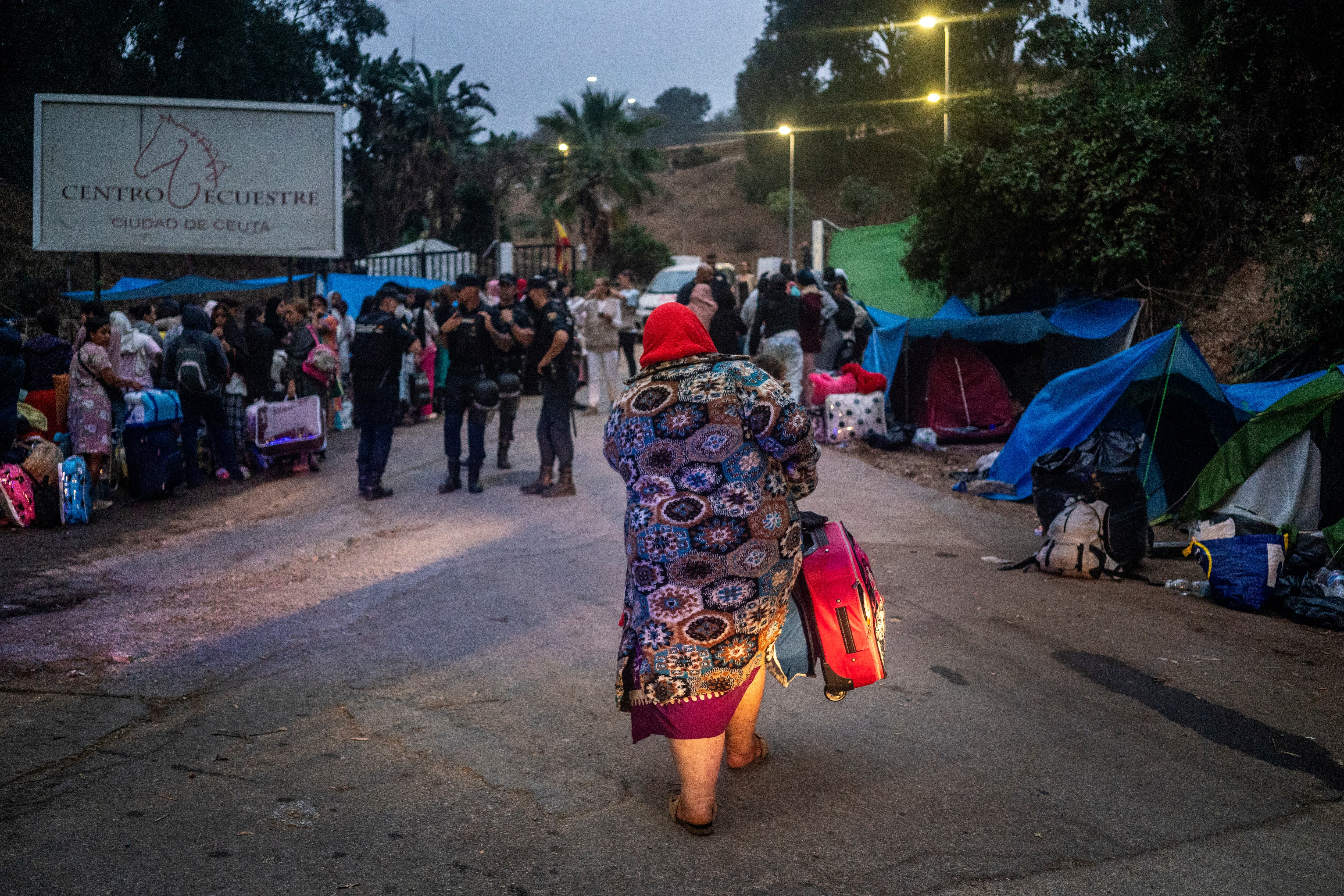 Una mujer migrante con su maleta antes de acceder a La Hípica de Ceuta.
