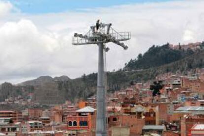 Un trabajador conecta el cable en una de las torres de la empresa austríaca Doppelmayr en La Paz (Bolivia). EFE/Archivo