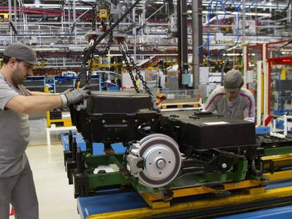 Dos operarios colocan las baterías de la furgoneta eléctrica Citroën Berlingo en la cadena de montaje de la planta de PSA. 