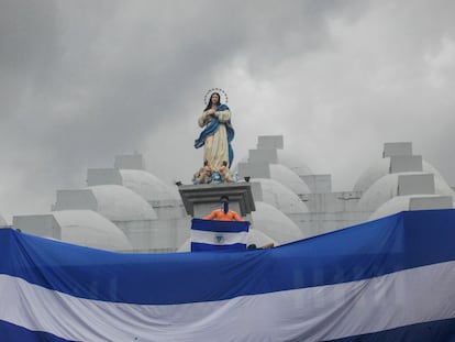 Un joven sostiene una bandera de Nicaragua en el techo de una catedral durante una protesta, en mayo de 2019.