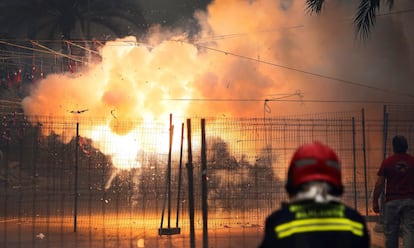 Un bombero observa el disparo de la sexta mascletá de las Hogueras de San Juan de Alicante.