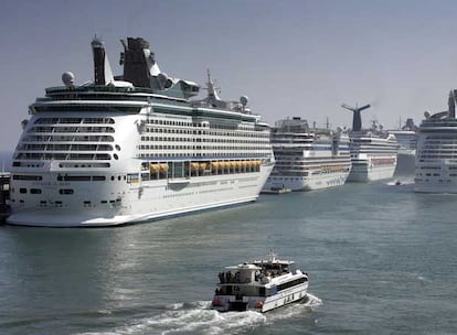 Cruceros en el puerto de Barcelona. Abajo, turistas de cruceros siguen a un guía en Barcelona.