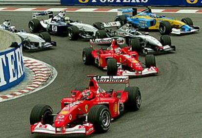 Schumacher pasa en cabeza la primera curva, y Barrichello, con el otro Ferrari, rebasa a Raikonnen.