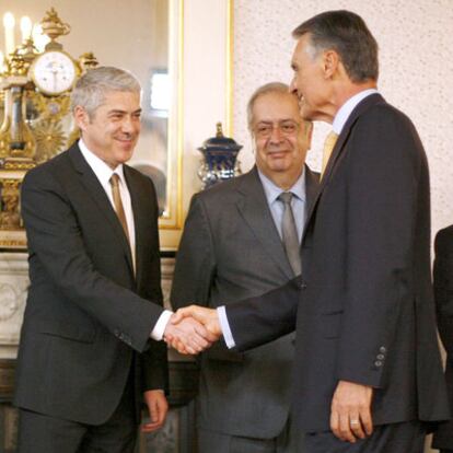 El primer ministro, José Sócrates (izquierda), estrecha la mano del presidente, Cavaco Silva, ante el ministro Teixeira dos Santos.