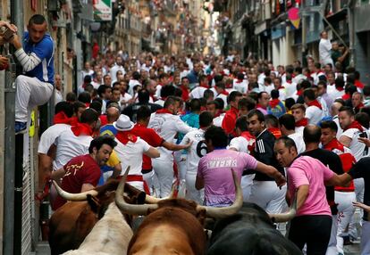 Los toros de la ganadería de Jandilla corren por las calles atestadas de Pamplona.