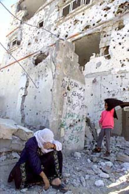 Una anciana palestina llora frente a una casa destruida en Gaza.