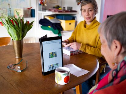 An older woman plays Wordle on her digital tablet.