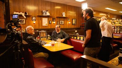 El cineasta Mark Fraga (derecha, de pie), ante Matt Zoller Seitz (izquierda, sentado) y Alan Sepinwall (centro, sentado), autores del libro 'The Sopranos Sessions' en el restaurante Holsten’s.