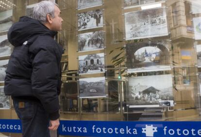 Un hombre contempla varias fotos antiguas expuestas en el escaparate de la fonoteca de Kutxa.