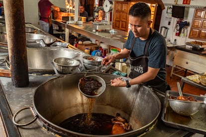 Un taquero saca carnitas del cazo con la mengambrea, el 6 de junio en Ciudad de México.