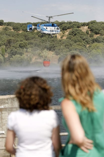 Vecinos  de la urbanización Cerro Alarcón, observan como cargan agua los helicópteros en el embalse Valdecañas (Madrid).