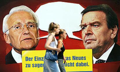 Dos jóvenes pasan en Berlín ante un cartel electoral del FDP que muestra al canciller Gerhard Schröder (derecha) y a su rival, Edmund Stoiber.