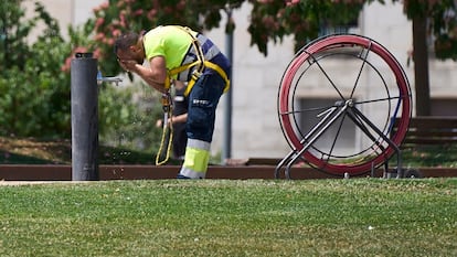 Un trabajador se refresca en una fuente, este lunes en Lleida. 