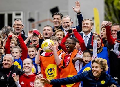 El rey Guillermo (tercero por la derecha en la última fila) y el rey Felipe VI  (cuarto por la derecha, en la última fila) posan con niños durante su visita a una tarde deportiva de la Fundación Cruyff en Ámsterdam.