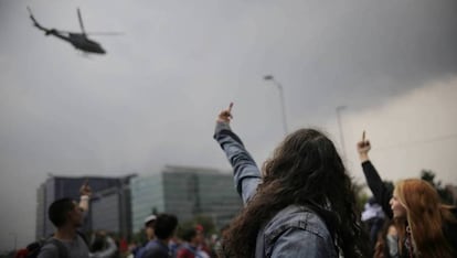 Manifestantes gesticulan contra un helicóptero de la policía colombiana.