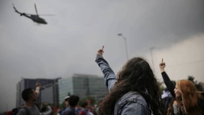 Manifestantes gesticulan contra un helicóptero de la policía colombiana. 