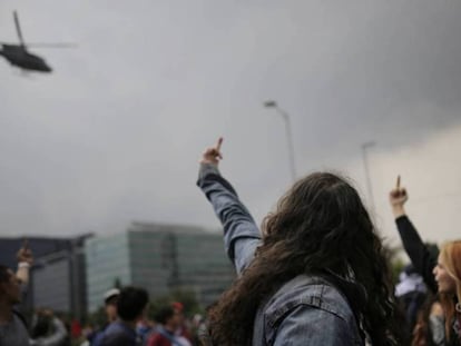 Manifestantes gesticulan contra un helicóptero de la policía colombiana. 