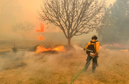 Una foto facilitada por el Departamento de Bomberos de Flower Mound (Texas) muestra a bomberos ayudando a contener un incendio forestal en la región del Panhandle de Texas.