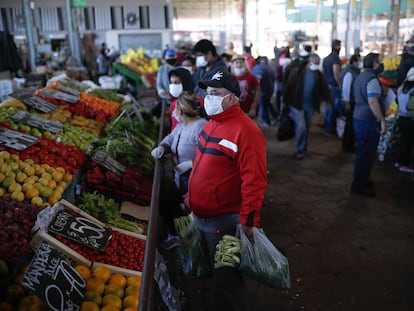 Personas con tapabocas hacen compras en el Mercado Central de Frutas y Verduras de la provincia de Buenos Aires, Argentina.
