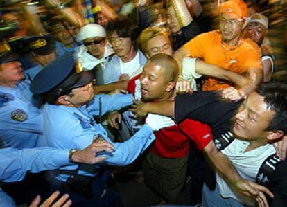 Un grupo de hinchas japoneses se enfrentan a la policía ayer, en Tokio, tras el Inglaterra-Suecia.