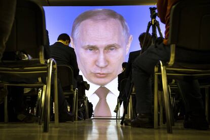 Varios peridostas siguen el discurso de Putin en Moscú.