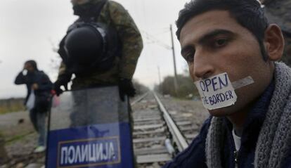 Un iraní espera en la frontera entre Grecia y Macedonia.
