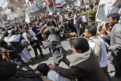 Partidarios del presidente Saleh, a la derecha, intentan agredir a manifestantes opositores, en Saná.