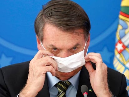 El presidente Bolsonaro se ajusta la mascarilla, este miércoles en Brasilia.