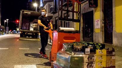 Un transportista descarrega aliments per a un comerç del centre de Girona.