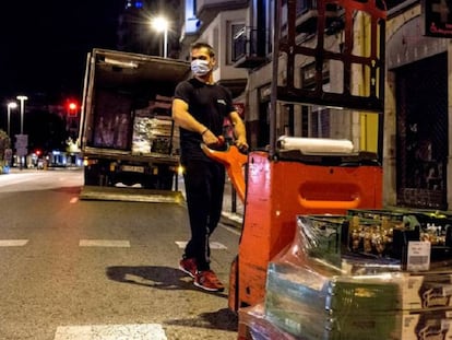 Un transportista descarrega aliments per a un comerç del centre de Girona.