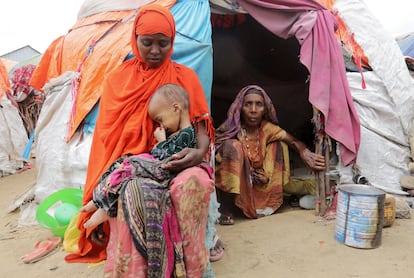 Una mujer somalí sostiene a su hija, mientras su abuela la observa, fuera de su refugio improvisado en el campamento de desplazados internos de Alla Futo, en las afueras de Mogadiscio, Somalia, el pasado septiembre.