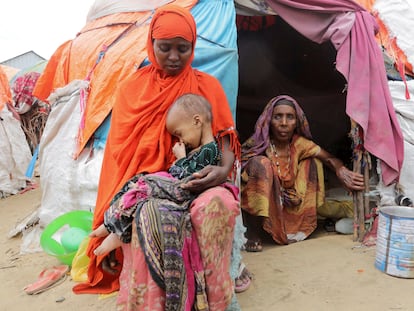 Una mujer somalí sostiene a su hija, mientras su abuela la observa, fuera de su refugio improvisado en el campamento de desplazados internos de Alla Futo, en las afueras de Mogadiscio, Somalia, el pasado septiembre.