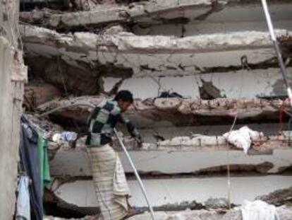 Un hombre busca a su hermano desaparecido entre los escombros del derrumbe de un edificio en Savar, en Dacca (Bangladesh).