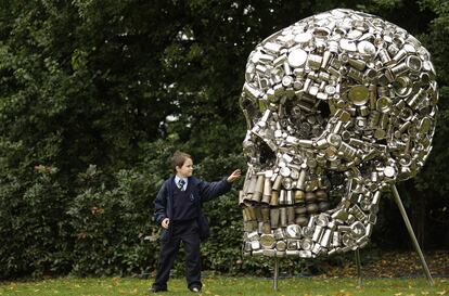 Un niño trata de tocar una calavera gigante, obra del artista indio Subodh Gupta, expuesta en Londres, en octubre de 2008.