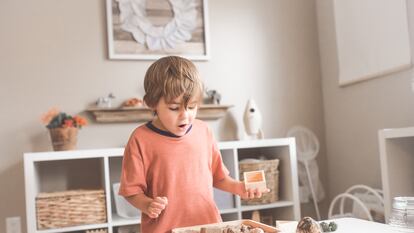 Menino olha admirado para uma caixa de brinquedos.