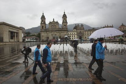 Funcionaris de l'alcaldia de Bogotà recorren la plaça Bolívar moments abans de l'acte d'inici del plebiscit per la pau a Colòmbia. La jornada s'ha caracteritzat per la pluja durant el matí.