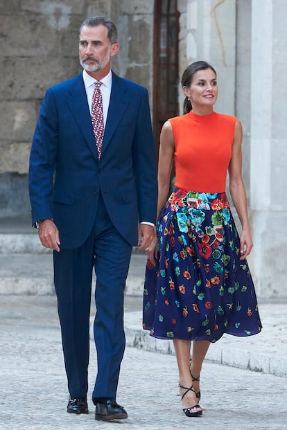 Flores solo en la falda (de Carolina Herrera) de la reina Letizia. ¿Un acierto? La idea de combinarla con un top en naranja saturado, en este caso de Hugo Boss.