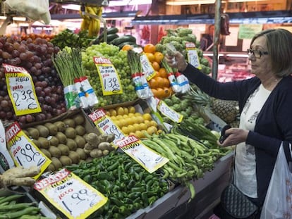 Una mujer hace su compra en una frutería del mercado Maravillas en Madrid.