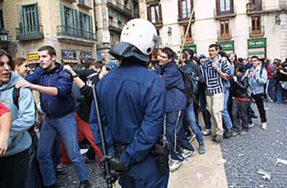 Un policía vigila la fila de manifestantes en una calle de Barcelona.