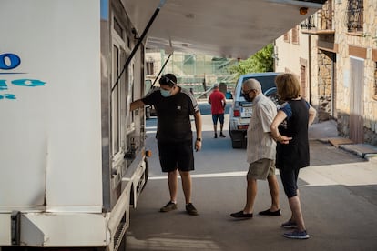 Tres vecinos de Griegos frente a un camión de venta ambulante. 