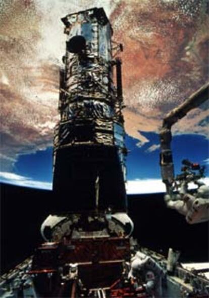 Reparación del <i>Hubble</i> en 1993, con la Tierra al fondo.