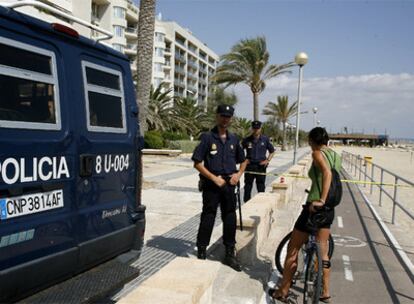 Agentes del Cuerpo Nacional de Policía impiden el paso a una ciclista en el paseo marítimo de Palma, acordonado después de producirse una de las explosiones.