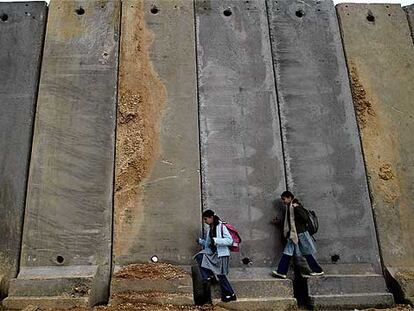Dos niñas palestinas circulan cerca de Ramala ante el muro de separación levantado por Israel.