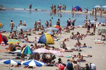 Turistas disfrutan de la playa y el buen tiempo en la localidad tinerfeña de Adeje. EFE/Archivo