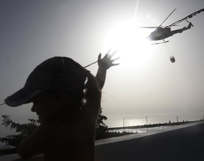 Un helicóptero de la toma de agua de una piscina para seguir la extinción del incendio forestal que comenzó hace cinco días en el sur de Tenerife, el 19 de julio de 2012.