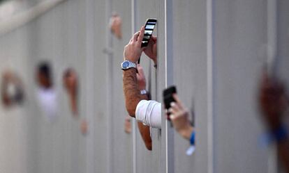 Espectadores del Gran Premio de Abu Dabi toman imágenes durante la carrera desde las gradas.