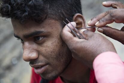 Un limpiador de oídos con un cliente. Muchos creen que tienen cera pero, en realidad, sufren sordera.