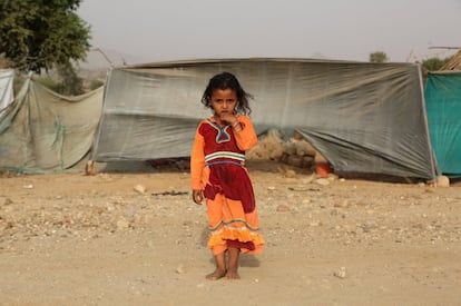 Una niña posa junto a la tienda de campaña familiar en el campamento de Shawqaba, habilitado para acoger a las 400 familias de la provincia de Hajja, al noroeste de Yemen, que tuvieron que huir de sus hogares debido a la guerra que azota el país desde hace más de un año. 